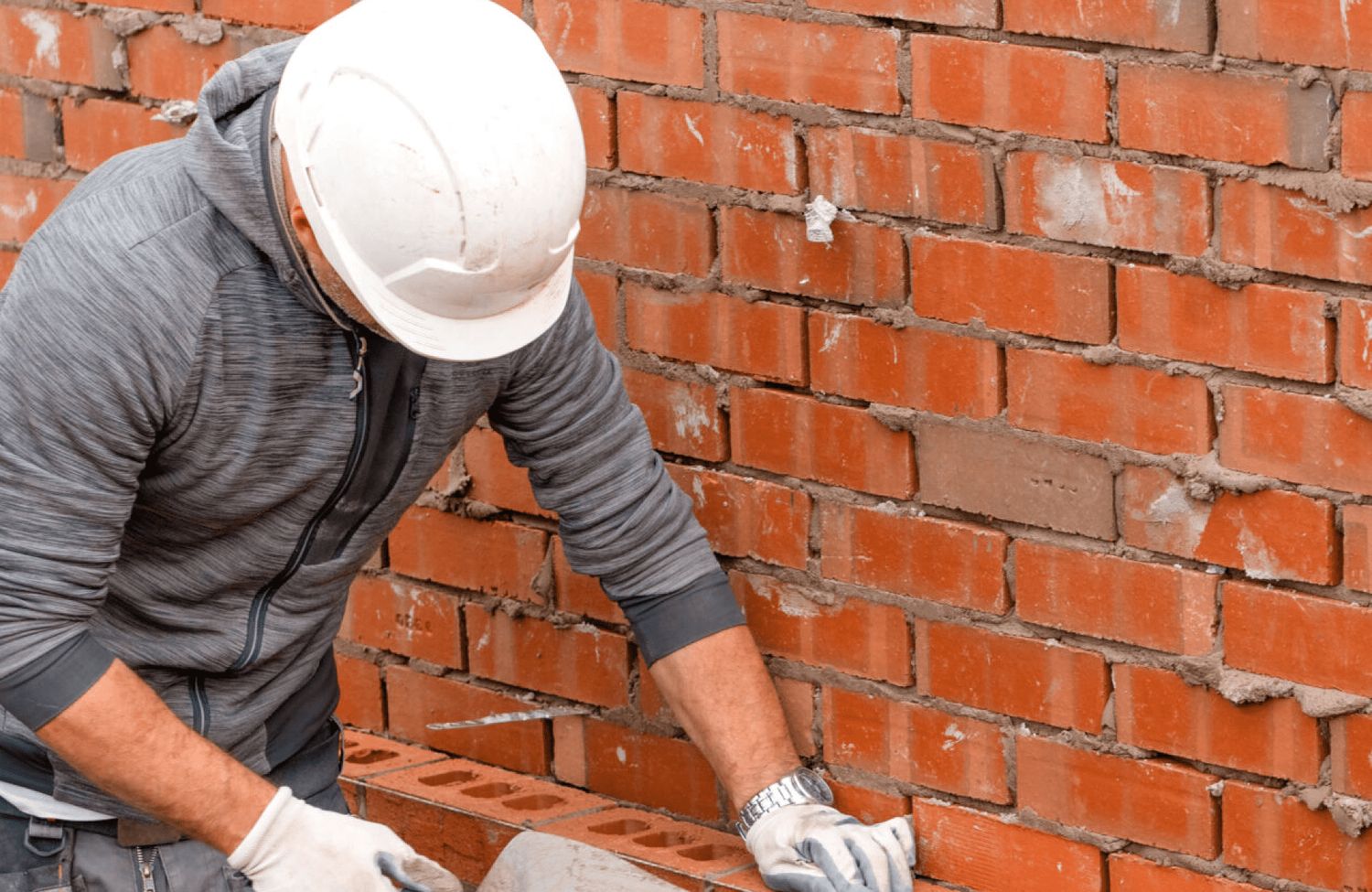 Mason rebuilding a brick chimney wall in Whittier, California