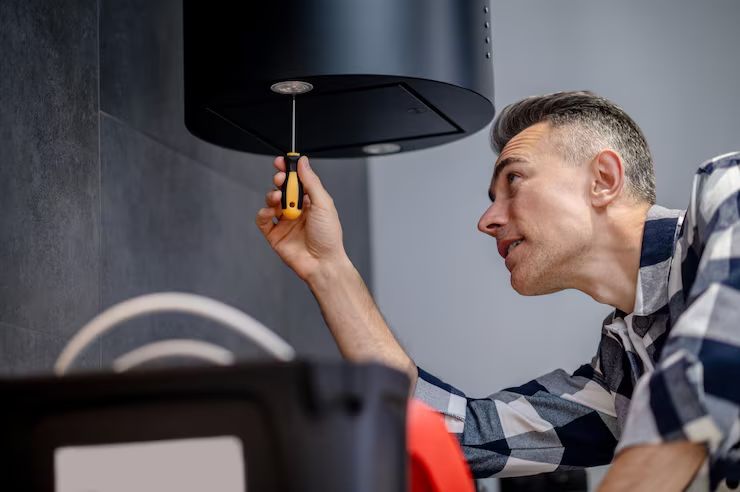 Technician servicing an appliance vent hood