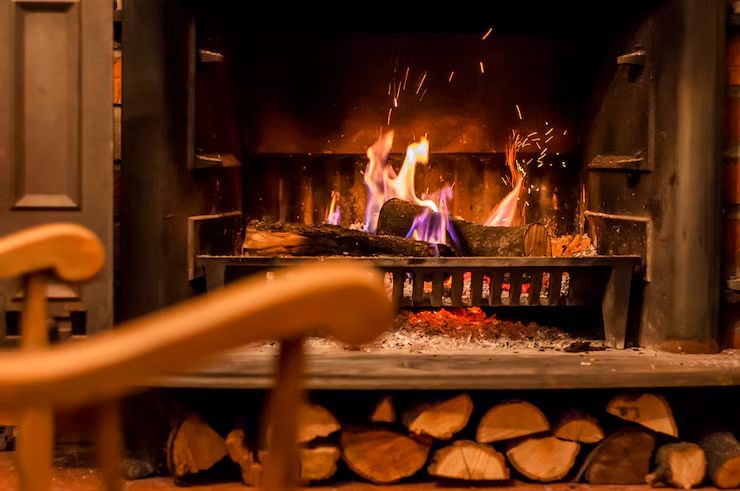 Restored fireplace burning logs in a Whittier home